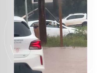 Carro fica parado em alagamento e ocupantes usam vasilhas para tirar água do veículo; VÍDEO